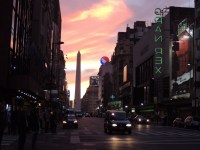 The sun paints the sky behind the obelisk on Av. Corrientes.